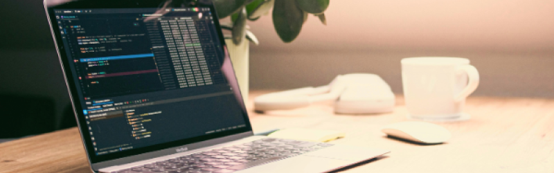 Ein Notebook und Handy auf einem Bürotisch.