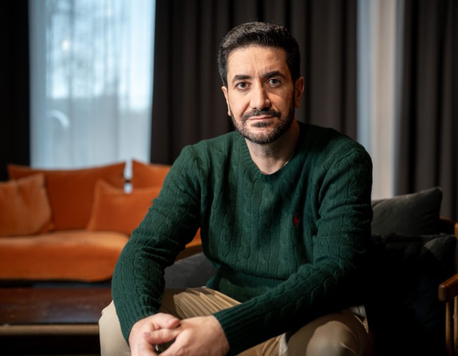 Steuerberater Tomas Aksöz auf einer Couch. Er schaut in die Kamera